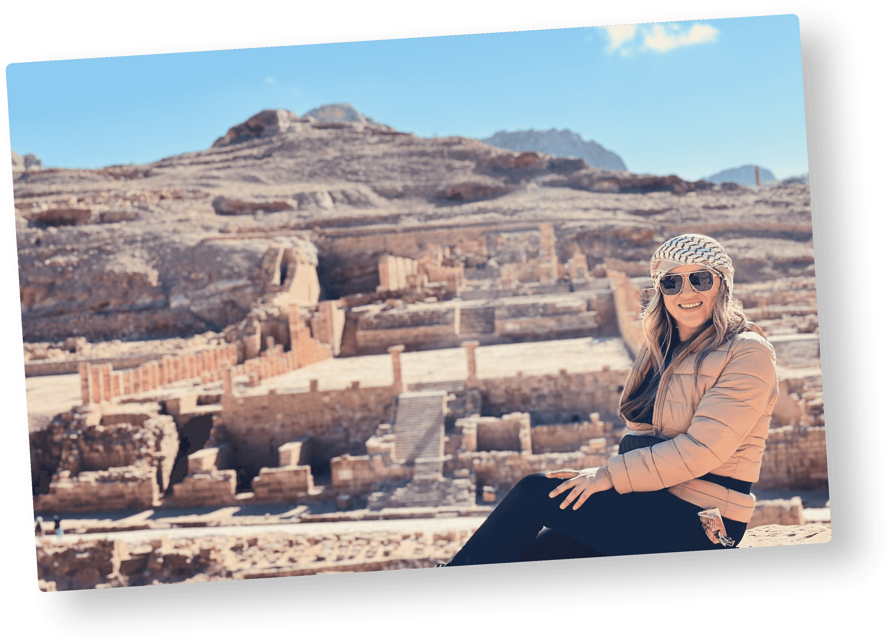 A favorite travel photo of a smiling woman at ancient desert ruins, ready to upload and turn into a postcard